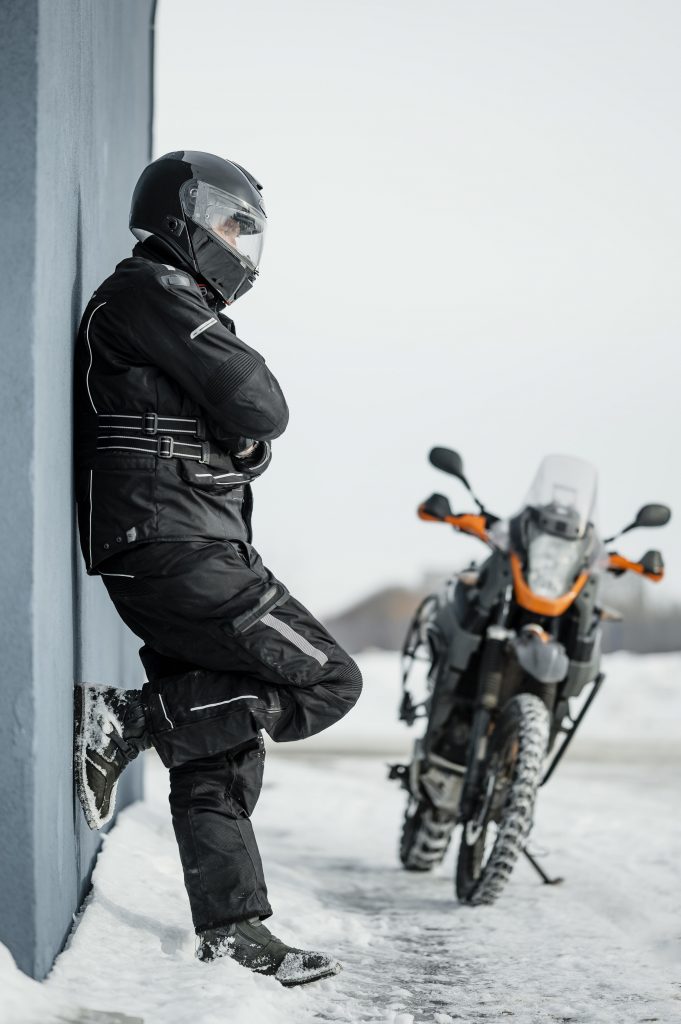 man-standing-beside-motorcycle-with-helmet